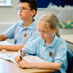 Bishopstrow Partner Schools, shows two students sat studying.